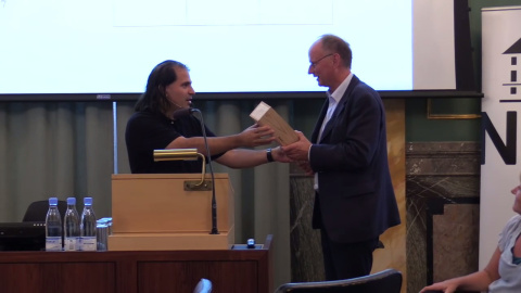 Nima Arkani-Hamed entrega una botella de coñac a su colega Poul Damgaard para saldar su apuesta, en Copenhague.- ACADEMIA DANESA DE CIENCIAS Y LETRAS Nima Arkani-Hamed entrega una botella de coñac a su colega Poul Damgaard para saldar su apuesta, en Copenhague.- ACADEMIA DANESA DE CIENCIAS Y LETRAS