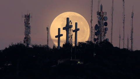 La luna llena se ve detrás de la colina de las tres cruces en Cali, Colombia. REUTERS/Jaime Saldarriaga
