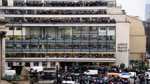 Periodistas de la agencia de prensa internacional France Presse posan ante su sede con carteles con la inscripción "Je suis Charlie", mientras guardan un minuto de silencio por las víctimas del atentado terrorista en el semanario satírico '