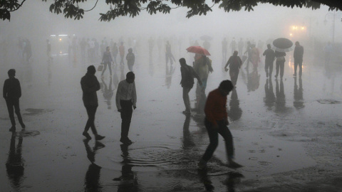 Personas caminando bajo las fuertes lluvias en la ciudad de Shimla, en el norte de la colina, en el estado de Himachal Pradesh. AFP