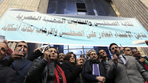 Journalists hold up pens as they participate in a silent protest against terrorism and in solidarity with the victims of a shooting by gunmen at the Paris offices of the satirical weekly newspaper Charlie Hebdo, in front of the Press Syndic
