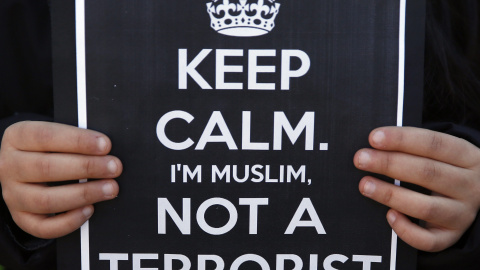A girl holds a sign during a rally by members of the Muslim community of Madrid outside Madrid's Atocha train station, January 11, 2015, in solidarity with the victims of a shooting by gunmen at the Paris offices of the satirical weekly new