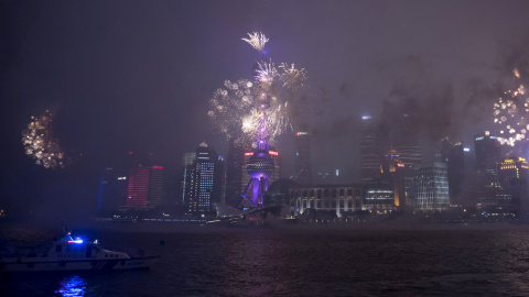 Fuegos artificiales iluminan el cielo del distrito financiero de Lujiazui en Shanghái durante las fuertes lluvias de otoño, el 28 de septiembre de 2015. AFP PHOTO / JOHANNES EISELE