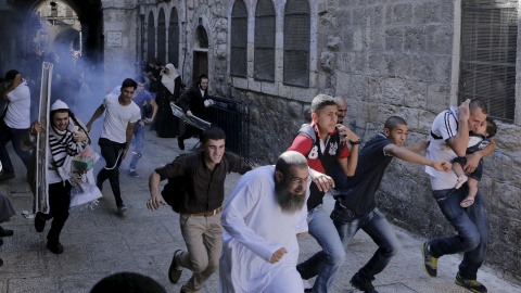 Manifestantes palestinos huyen mientras la policía israelí lanza una granada aturdidora en la Ciudad Vieja de Jerusalén, 28 de septiembre de 2015. REUTERS / Ammar Awad