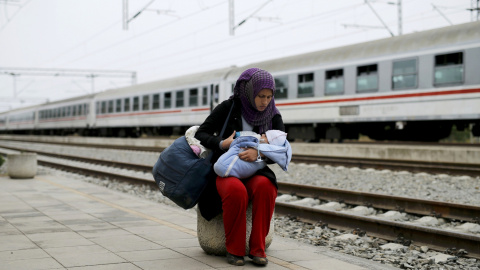 Una emigrante da el biberón a su hijo antes de subirse abordo de un tren en la estación de Tovarnik en Croacia, 28 de septiembre de 2015. REUTERS/Antonio Bronic