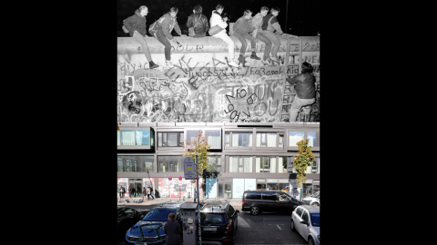 Ciudadanos de Alemania Occidental sentados en la parte superior del Muro de Berlín en Zimmer Strasse, cerca del puesto de control aliado Charlie después de que se anunciara la apertura de la frontera con Alemania Oriental el 9 de noviembre 
