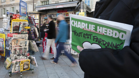 Un hombre sostiene junto a un quiosco en Niza el último ejemplar del semanario 'Charlie Hebdo' que muestra en la portada una caricatura de Mahoma con la frase "Todo está perdonado". REUTERS/Eric Gaillard