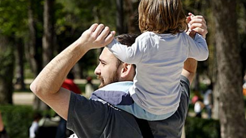 Un padre pasea con su hijo a hombros - EFE
