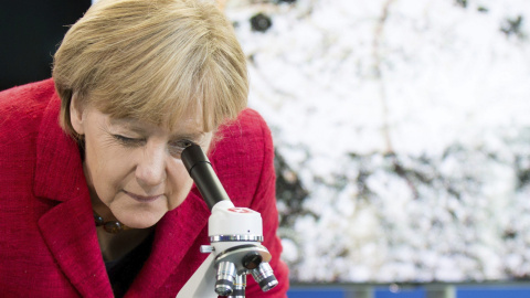 La canciller alemana Angela Merkel observa a través de un microscopio en la Cancillería alemana en Berlín (Alemania) hoy, 30 de septiembre de 2015. Merkel invitó a los ganadores del concurso de ciencias "La Juventud en la Ciencia". EFE/Kay 