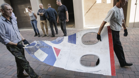 Investigadores de la Oficina del Fiscal de la autoproclamada República de Donetsk trasnportan los restos del Boeing 777 que hacía el trayecto entre Amsterdam y Kuala Lumpur y en el que viajaban 295 personas a bordo, en la localidad de Donet