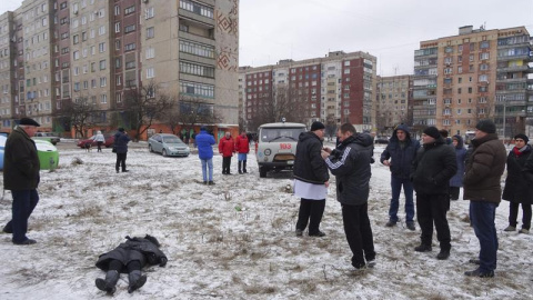 Varias personas observan el cuerpo sin vida de una mujer tras un bombardeo en una calle de Kramatorsk, Ucrania, el 10 de febrero del 2015. El presidente de Ucrania, Petró Poroshenko, denunció hoy que las milicias prorrusas atacaron con misi