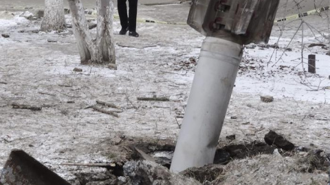 Varias personas caminan junto a un cohete caído en una calle de Kramatorsk, Ucrania, el 10 de febrero del 2015. El presidente de Ucrania, Petró Poroshenko, denunció hoy que las milicias prorrusas atacaron con misiles Tornado la sede del Est