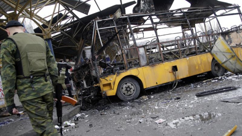 Rebeldes prorrusos investigan la zona donde impactaron varios proyectiles de artillería en Donetsk (Ucrania), hoy, miércoles 11 de febrero de 2015. Al menos seis civiles murieron y otros ocho resultaron heridos por fuego de artillería en un