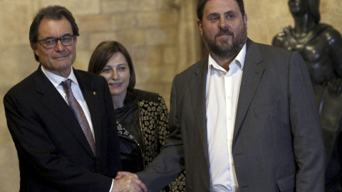 El presidente de la Generalitat, Artur Mas, y el lider de ERC, Oriol Junqueras, se estrechan la mano ante la presidenta de la Asamblea Nacional Catalana (ANC), Carme Forcadell. EFE/Alejandro García.