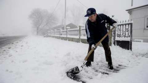 Un hombre retira la nieve con una pala en la entrada de su casa en la localidad ourensana de Casetas de Rodicio (Maceda) que amanecía hoy nevado debido al temporal de frío y viento que afecta a Galicia y gran parte de la península. EFE/Brai