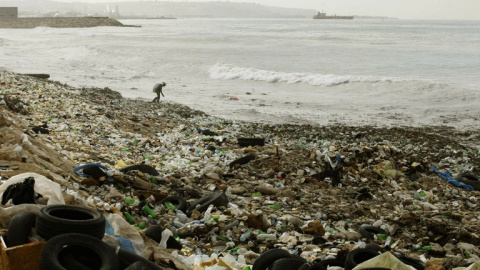 Un hombre recoge basura de entre los montones de plástico de una playa en el sur del Líbano, en la costa Mediterránea. AFP Un hombre recoge basura de entre los montones de plástico de una playa en el sur del Líbano, en la costa Mediterránea. AFP