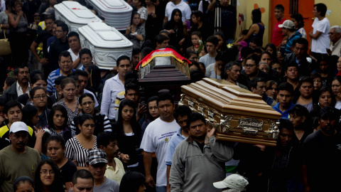 Amigos y familiares cargan los ataúdes de cinco personas que murieron en el deslave en Santa Catarina Pinula (Guatemala). Siguen las labores de búsqueda de las 300 personas desaparecidas por un alud que arrasó con un asentamiento y que prod