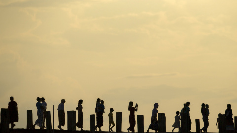 Gente cruza el puente U Bein sobre el lago Tuangthaman en Mandalay, Birmania. REUTERS / Jorge Silva