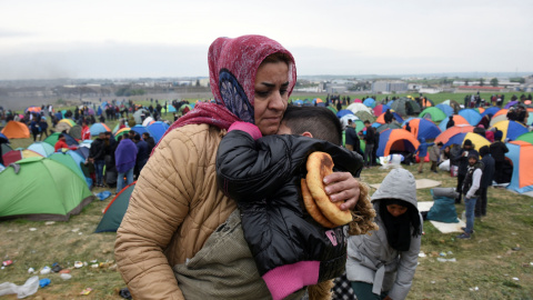 Una mujer sostiene a su hijo en el campamento de Diavata, en el norte de Grecia. REUTERS/Alexandros Avramidis