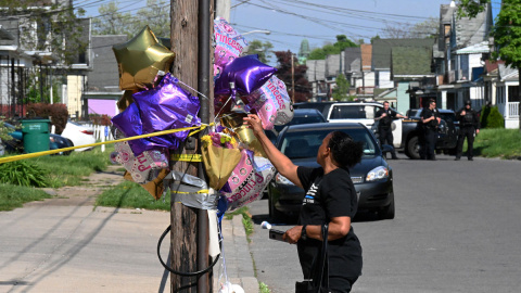 Una mujer deja un globo en un monumento improvisado cerca de una tienda Tops Grocery en Buffalo, Nueva York, el 15 de mayo de 2022, el día después de que un hombre armado matara a tiros a 10 personas. Los residentes afligidos de la ciudad Una mujer deja un globo en un monumento improvisado cerca de una tienda Tops Grocery en Buffalo, Nueva York, el 15 de mayo de 2022, el día después de que un hombre armado matara a tiros a 10 personas. Los residentes afligidos de la ciudad