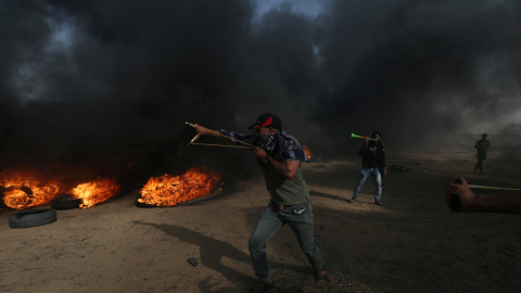 Un manifestante usa un tirachinas para arrojar piedras durante una protesta en la que los palestinos reclaman el derecho a regresar a su patria, en la frontera entre Israel y Gaza. REUTERS / Ibraheem Abu Mustafa