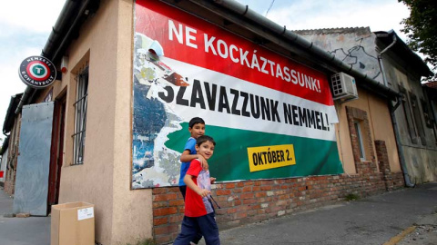 Dos niños inmigrantes pasan ante un cartel en Budapest que pide el 'No' en la consulta sobre migración. / REUTERS Dos niños inmigrantes pasan ante un cartel en Budapest que pide el 'No' en la consulta sobre migración. / REUTERS
