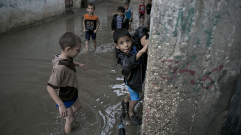 Niños palestinos en una calle inundada después de fuertes lluvias en Khan Yunis, en el sur de la Franja de Gaza el 07 de octubre de 2015. AFP PHOTO / SAID KHATIB