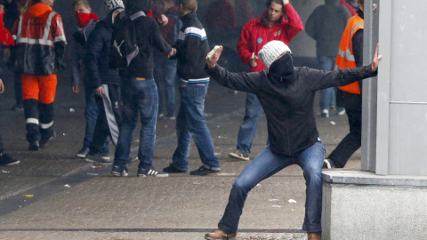 Un manifestante lanza piedras contra la Policía durante una manifestación contra la austeridad en Bruselas.- REUTERS/Yves Herman