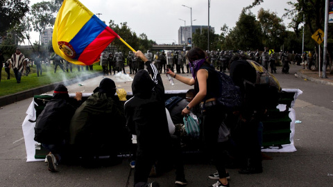 21/11/2019.- Un grupo de jóvenes se cubre frente a miembros de la Policía durante una manifestación en Bogotá (Colombia). / EFE - JUAN ZARAMA 21/11/2019.- Un grupo de jóvenes se cubre frente a miembros de la Policía durante una manifestación en Bogotá (Colombia). / EFE - JUAN ZARAMA