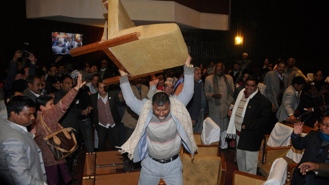 Un miembro de la oposición en la asamblea constituyente de Nepal lanza una silla. /BIKASH DWARE (REUTERS)