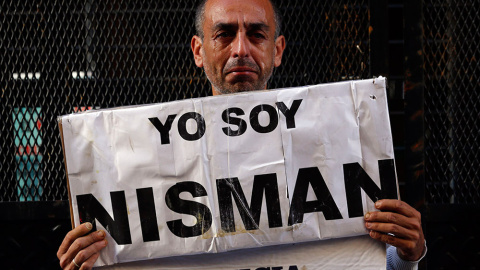 Marcelo Novillo, cuyo hijo Adrian fue víctima de un crimen violento, llora mientras sostiene un cartel que dice "Yo soy Nisman" ante la oficina de un fiscal que investiga la muerte del fiscal Alberto Nisman, en Buenos Aires. / MARCOS BRINDI
