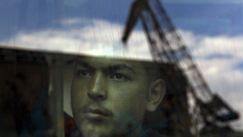 Un inmigrante afgana se ve el interior de un autobús después de su llegada por el ferry de pasajeros Eleftherios Venizelos , con más de 2.500 migrantes y refugiados de la isla de Lesbos en el puerto de El Pireo. REUTERS