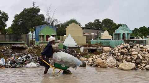 Una mujer empuja una carretilla en una calle inundada de Puerto Príncipe, Haití. - AFP Una mujer empuja una carretilla en una calle inundada de Puerto Príncipe, Haití. - AFP