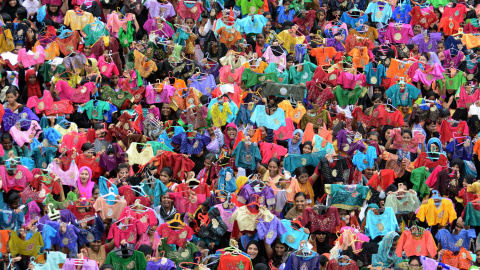 Estudiantes indios sostienen blusas pintados y decorados en un colegio en Chennai. AFP PHOTO/STR