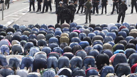 Policías fronterizos hacen guardia frente a un grupo de palestinos durante los rezos del viernes en Jerusalén (Israel) hoy, 9 de octubre de 2015. EFE/Abir Sultan