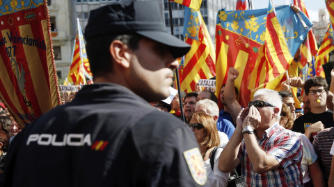 Asistentes a la procesión cívica que recorre las calles del centro de Valencia con la senyera hasta la estatua del rey Jaime I, con motivo del 9 d'Octubre, protestan a su paso. EFE/Kai Försterling