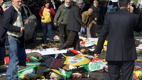 Varias personas cubren con banderas y pancartas a las víctimas mortales provocadas por los atentados en centro de Ankara durante una marcha pro-kurda. EFE/EPA/STR