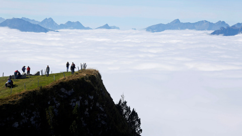 Los turistas caminan bajo el sol en la montaña Niederhorn, cerca de Interlaken, Suiza. REUTERS / Ruben Sprich