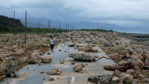 Una mujer camina en una carretera bloqueada por rocas tras el paso del huracán Mateo en la costa de la provincia de Guantánamo, Cuba. REUTERS / Alexandre Meneghini