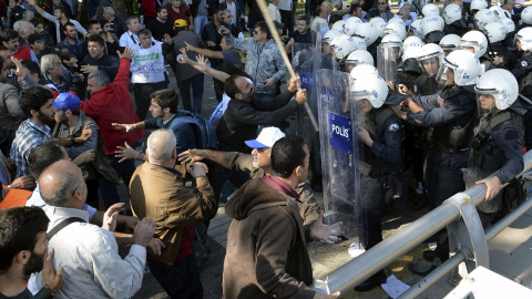 Algunos de los participantes en la marcha pro-kurda se encaran a los agentes de la Policía turca tras las explosiones en el centro de Ankara que han provocado decenas de muertos y más de un centenar de heridos. REUTERS/Stringer
