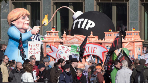 Un muñeco que representa a la canciller alemana, Angela Merkel, encendiendo 'la bomba TTIP', en la manifestación de Berlín contra el acuerdo comercial que negocia la UE con EEUU. EFE / EPA / JOERG CARSTENSEN Un muñeco que representa a la canciller alemana, Angela Merkel, encendiendo 'la bomba TTIP', en la manifestación de Berlín contra el acuerdo comercial que negocia la UE con EEUU. EFE / EPA / JOERG CARSTENSEN