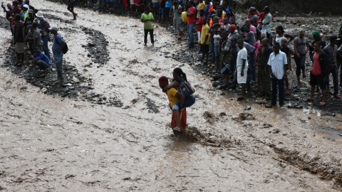 Personas intentan cruzar el río La Digue, debido al derrumbe del único puente que conecta con el sur, tras el paso del huracán Matthew en Haití. EFE Personas intentan cruzar el río La Digue, debido al derrumbe del único puente que conecta con el sur, tras el paso del huracán Matthew en Haití. EFE