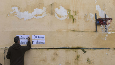 Un funcionario de la comisión electoral escribe en un cartel en un colegio elecoral en Atenas. REUTERS/Marko Djurica