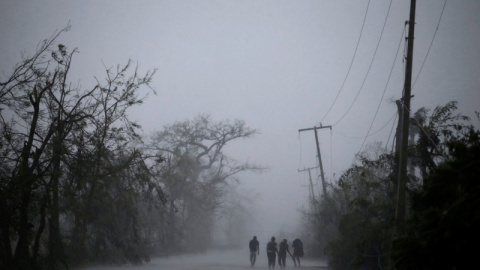 Un grupo de personas camina mientras cae una fuerte lluvia al paso del huracán Matthew en Les Cayes, Haiti. REUTERS/Andres Martinez Casares