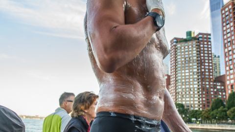 Christian Jongeneel untándose grasa antes de comenzar a nadar alrededor de Manhattan.