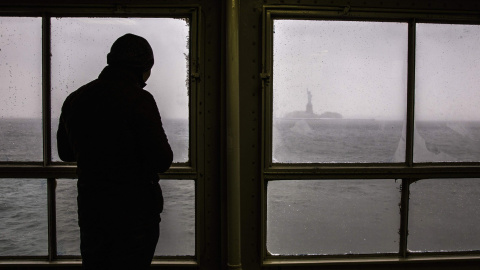 Un hombre observa la Estatua de la Libertad. REUTERS/Elizabeth Shafiroff