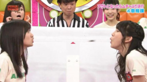 Dos participantes del concurso AKBingo compiten por no tragarse una cucaracha. Dos participantes del concurso AKBingo compiten por no tragarse una cucaracha.