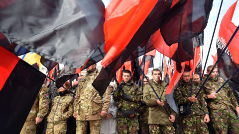 Los miembros del movimiento de extrema derecha Right Sector y simpatizantes de partidos nacionalistas ondean banderas mientras asisten a un mitin en Kiev el 14 de octubre de 2015, para conmemorar el Día para Defender Ucrania y pedir la inde