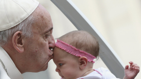 El Papa Francisco besa a un bebé a su llegada a la plaza de San Pedro en el Vaticano, 14 de octubre de 2015. REUTERS / Stefano Rellandini