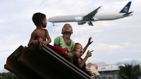 Niños juegan junto a un río en Parañaque, Filipinas, hoy 14 de octubre de 2015. El servicio meteorológico filipino Pagasa advirtió de riesgos de inundaciones este fin de semana en la provincia de Cagayan debido a la llegada del tifón Koppu.